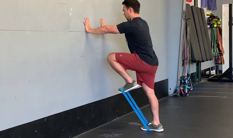 Standing Psoas March demonstrating resistance band use